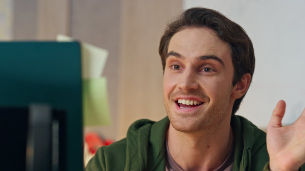 愉快的男子打招呼视频电话电脑办公室特写。造物主说图片下载