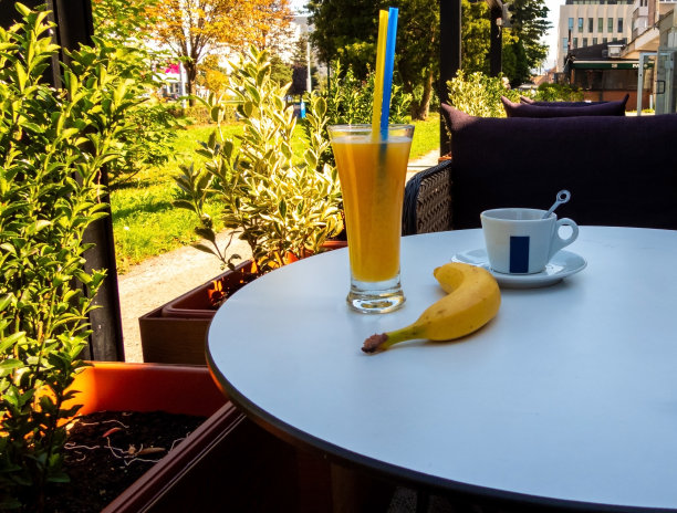 一根香蕉和橙汁放在咖啡桌上图片下载