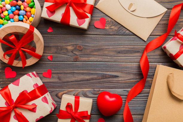 情人节装饰购物的俯视图照片，包，信封，礼物，盒子，糖果和红色的心在彩色背景与空白的空间。帧的背景图片下载