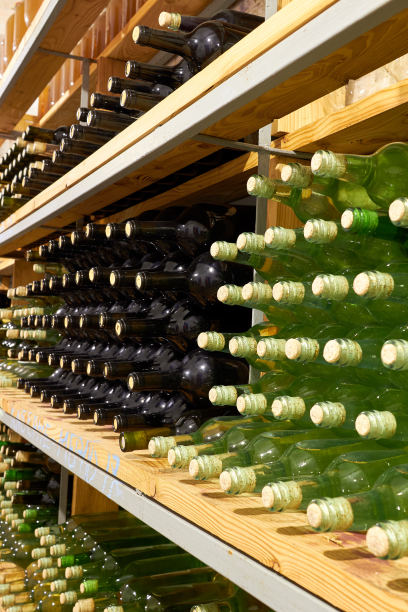 酒窖的架子上一排排的红酒瓶和白酒瓶。近距离图片下载