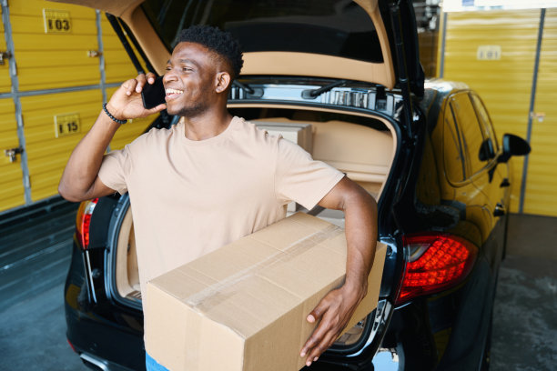 一个非裔美国人把后备箱卸下来，一边打电话图片下载