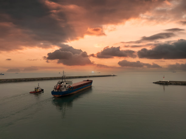 货船驶出港口时，拖船跟着它。İnternational海洋运输。图片下载