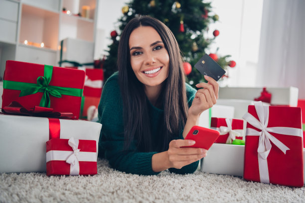 照片正面迷人的女士躺在地板上拿着银行卡选择礼物网上商店app舒适服务神奇的时间房间房子室内图片下载