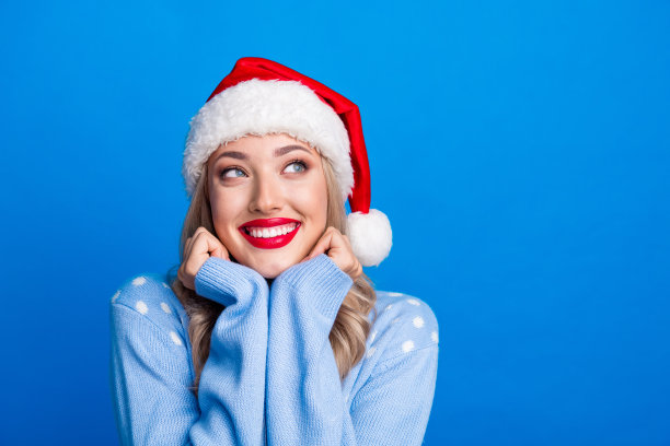 迷人的金发女郎的照片肖像欣赏看空空间穿毛衣圣诞帽孤立的蓝色背景图片下载