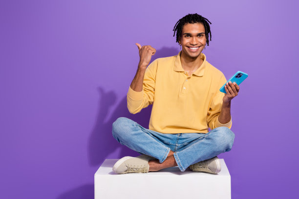 坐在白色平台上的全身照片，手机建议更新ios系统，在紫色背景上显示手指模型图片下载