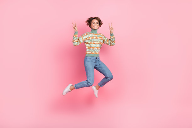 跳时髦女孩鲍勃棕色头发的全长图片显示两个v标志符号和平运动孤立在粉红色的背景图片下载