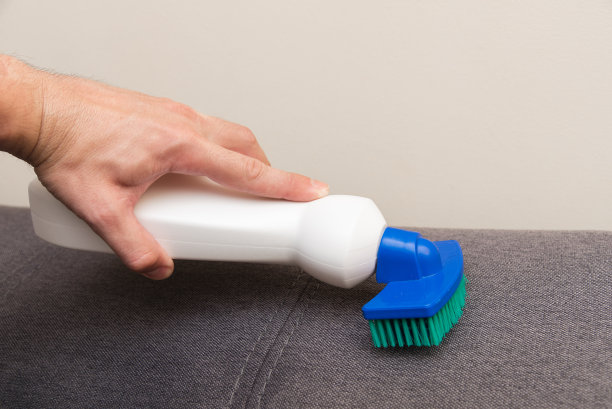 用清洁产品用海绵和刷子清洁沙发。图片下载