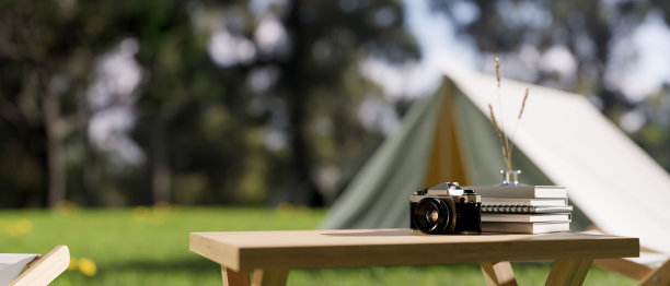 有帐篷的露营地或丛林中的露营地的模糊背景的木桌。图片下载