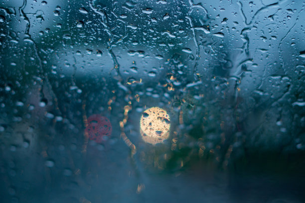 一个骑摩托车的男人透过雨中的镜子。-库存照片图片下载