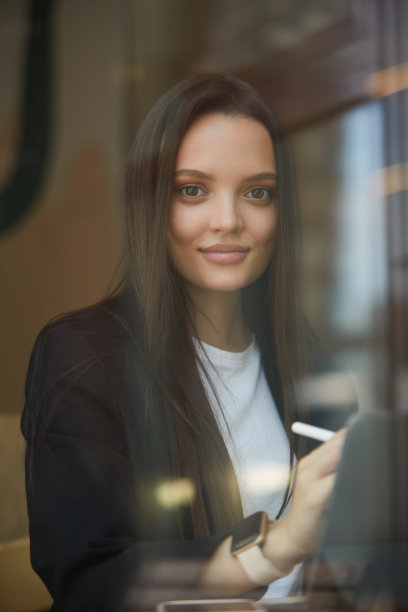 可爱的年轻女性正在平板电脑上画画。在餐馆工作的自由插画师图片下载