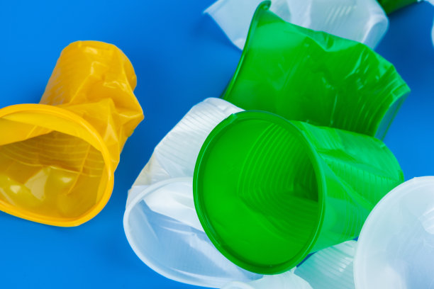 揉皱的一次性空塑料杯，摄影棚照片。塑料污染概念图片下载