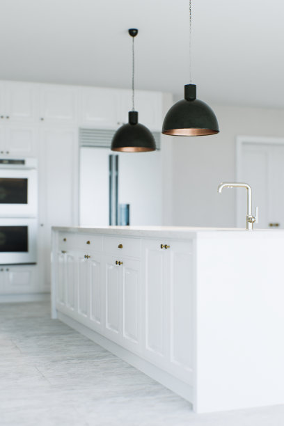 白色厨房里的厨房岛的景色。黑暗的灯光笼罩着小岛。背景是厨房电器。岛上的厨房水槽。3 d渲染。图片下载