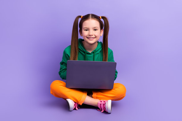 漂亮迷人的小女孩穿着绿色卫衣聊天苹果三星设备孤立的紫色背景的全长照片图片下载