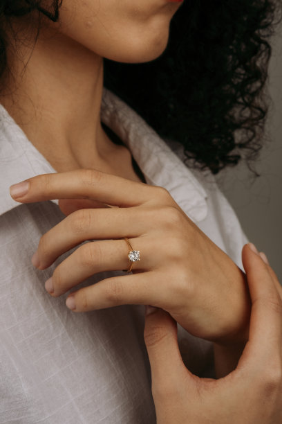 金戒指戴在女性的手上，钻石钻石戒指在年轻女士的手上。特写照片拍摄图片下载