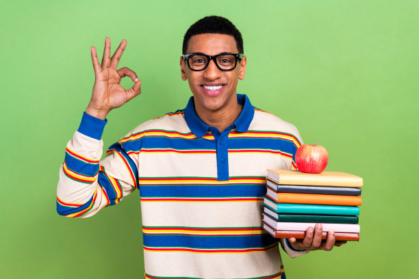 年轻勤奋的学生的照片年轻人好的标志同意阅读更多帮助生活更聪明吃午餐苹果孤立在绿色的背景图片下载