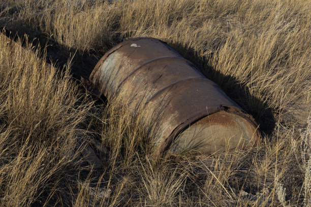 一个生锈的旧金属油桶污染了景观图片下载