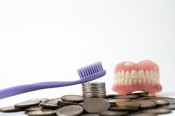 白色背景上的牙刷和硬币图片下载