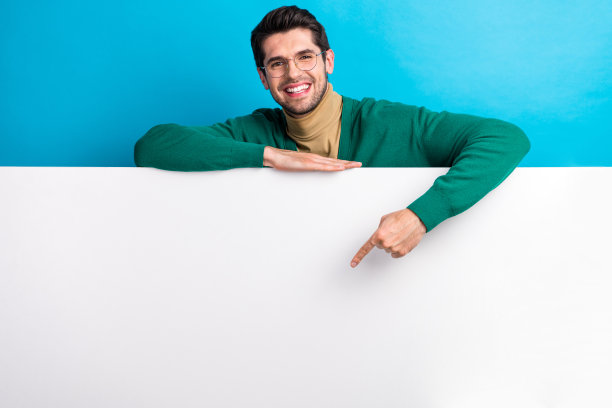 开朗的年轻人企业家的照片肖像，指空的空间广告牌互联网广告孤立在蓝色的背景图片下载