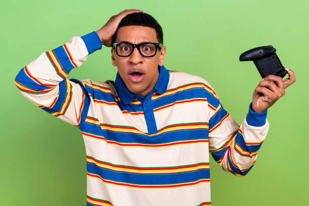 照片中震惊的印象的情绪手头强调年轻人麻木滞后，他的游戏手柄孤立在绿色的背景图片下载