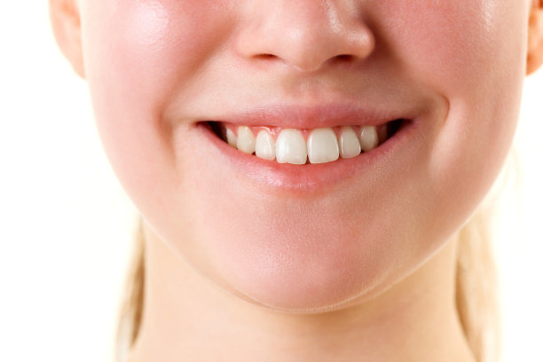 剪短的照片，年轻的微笑与牙齿女性的脸，嘴唇没有口红。自然光泽的嘴唇和女人的皮肤。增加唇部美容。图片下载