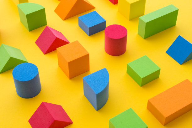 一套彩色几何立方体或块玩具在黄色的背景。图片下载