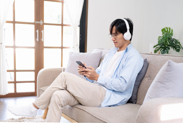 沙发上的男人用手机看电影图片下载