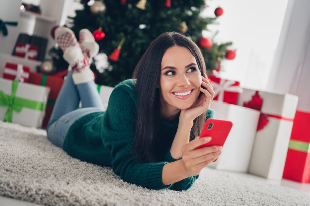 漂亮快乐的女士的照片用户躺在地板上仰望想象圣诞老人等待午夜新年的神奇奇迹的房子在室内图片下载