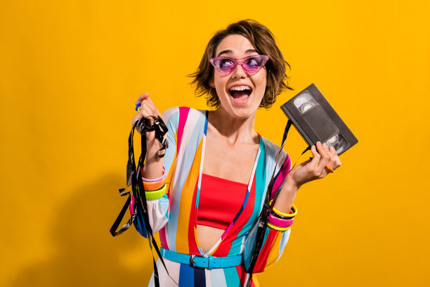 兴奋的女孩准备生日聚会的照片，看着电影磁带记录孤立的鲜艳的色彩背景图片下载