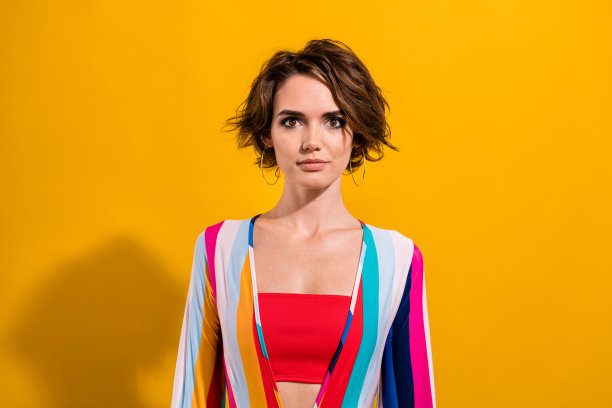 照片可爱可爱的女孩穿着彩色鲜艳的服装庆祝主题派对孤立的黄色背景图片下载