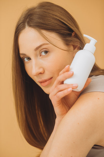 女人拿着化妆品管。在米色背景上完美化妆的迷人女人的照片。美丽的概念图片下载