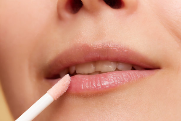 剪短的特写图片，年轻女孩在嘴唇后开车，涂保湿唇膏，油图片下载