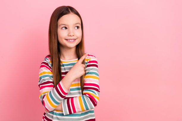 照片开朗梦幻的小女儿女孩指着空白的空间信息模型品牌标志孤立在粉红色的背景图片下载