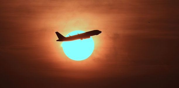 太阳在天空中变成了红色，形成了这张飞机的照片图片下载