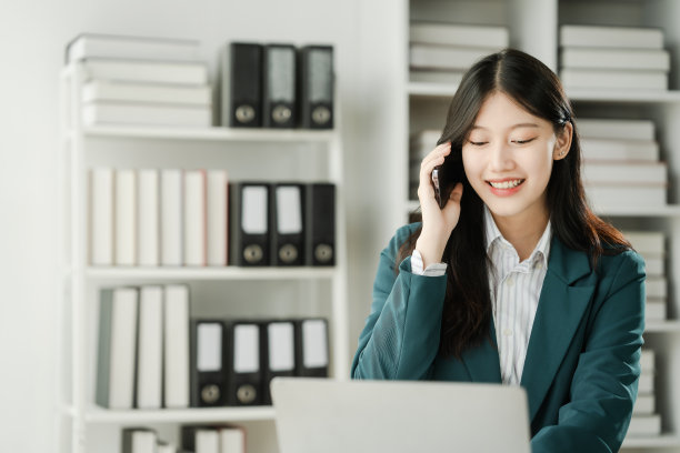 金融机构工作人员亚洲女性，专注于工作的专业人士。商务人士孜孜不倦地处理数字，为客户提供建议，并在办公桌前敲定交易。图片下载