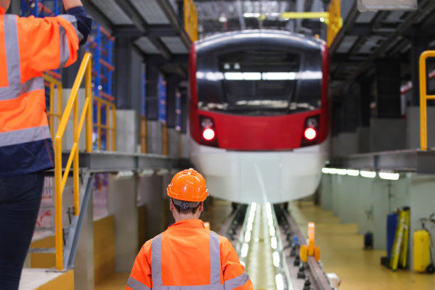 两名身穿安全制服的铁路工程师向电动列车发出手势图片下载