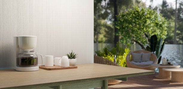 一个咖啡机和一盘咖啡杯放在木桌子上，有一个平台，可以看到令人惊叹的自然景观。图片下载
