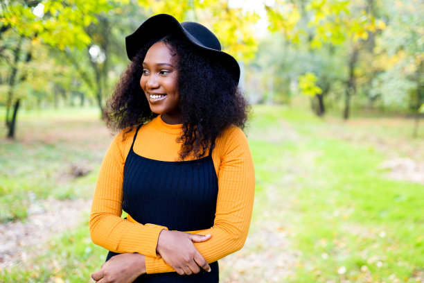 迷人的卷发的轮廓肖像深色皮肤女士露齿微笑有好心情自由时间周末户外图片下载