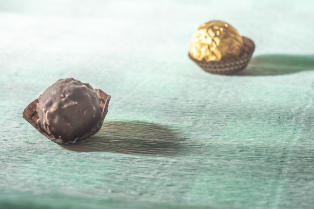 巧克力和金色锚在浅绿色的毛巾上。图片下载