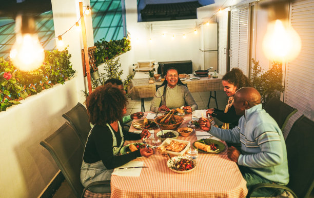 快乐的非裔美国家庭在户外露台上一起吃晚餐-假日生活方式概念-温柔地关注母亲的脸图片下载