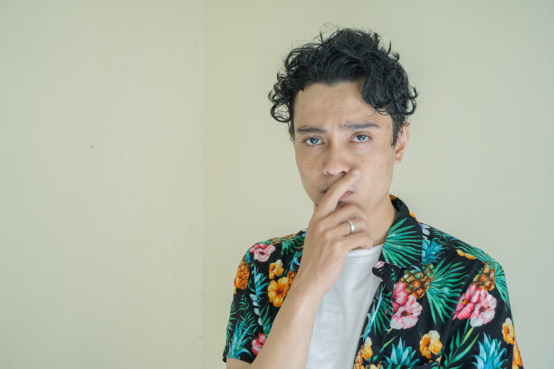 卷毛男人穿着沙滩装，摆出思考的姿势和姿势。图片下载