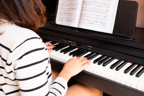 女人的手在弹钢琴，她用音乐来放松和缓解压力。看音乐家的特写照片。爱好的概念图片下载