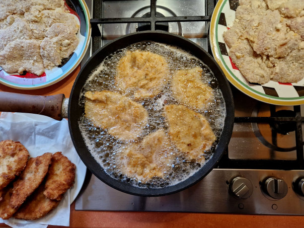 维也纳炸猪排。在平底锅里用油煎，然后放在盘子里备用。餐巾纸可以吸收包裹在鸡蛋周围的面包屑中的油图片下载