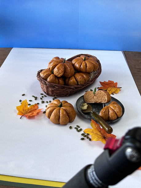 图片背后的美食摄影工作室的照片拍摄设置，拍摄一堆南瓜设计的卷与青椒梗在柳条篮子包围的南瓜籽，高架视图图片下载