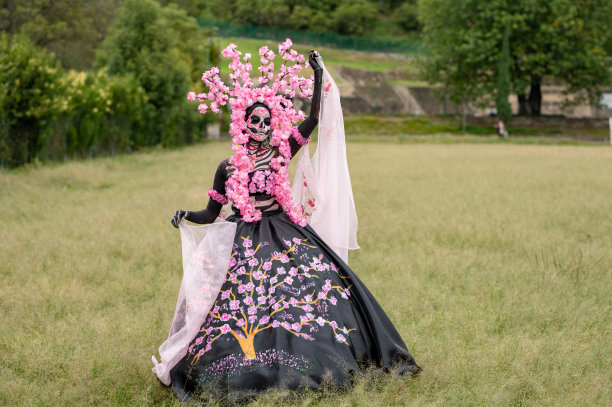 迷人的卡特里娜:Día de los Muertos照片在乔卢拉的Cempasuchil领域，由标志性的乔卢拉教堂框架，庆祝美丽，传统，和迷人的粉红色烟雾图片下载