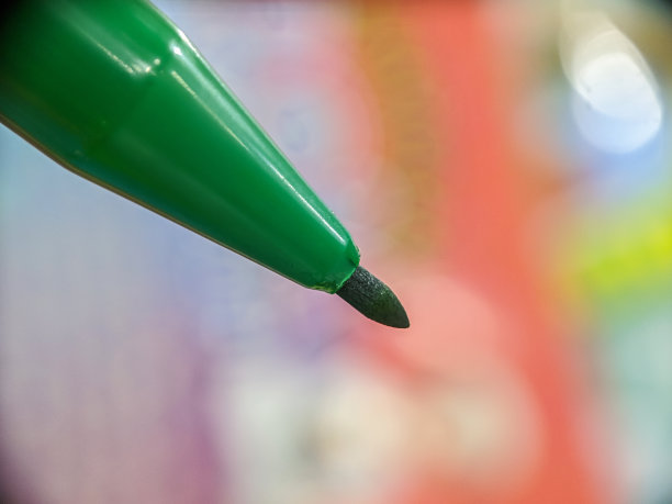 宏观的绿色标记顶端与模糊的背景图片下载