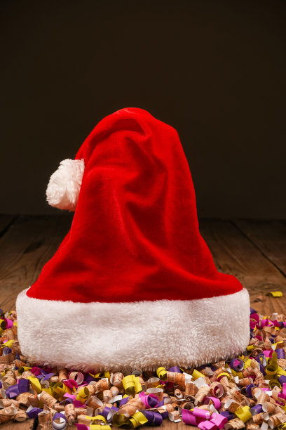 圣诞Flatlay礼盒和圣诞树装饰品的俯视图照片。木制背景上的圣诞老人帽子。圣诞背景与文字的地方。Copyspace。圣诞树玩具。图片下载