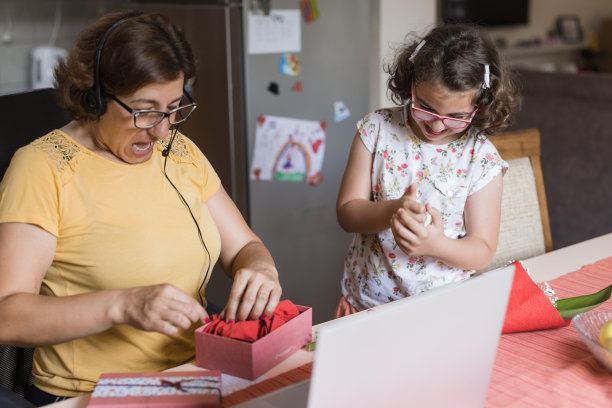 一位女士正在打开女儿送给她的礼物图片下载