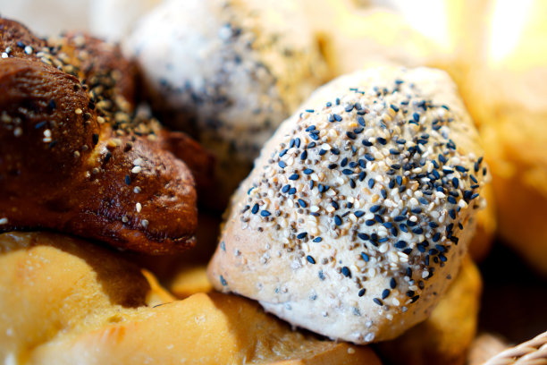 一张特写照片，面包篮子里放着烤面包，上面撒着白芝麻和黑芝麻。图片下载
