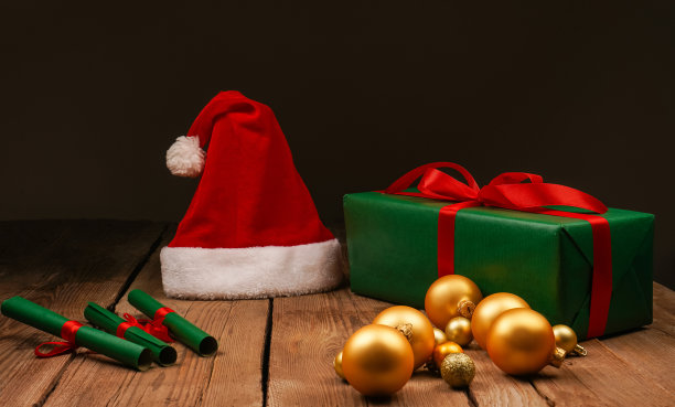 圣诞Flatlay礼盒和圣诞树装饰品的俯视图照片。木制背景上的圣诞老人帽子。圣诞背景与文字的地方。Copyspace。圣诞树玩具。图片下载