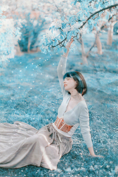 黑发亚洲女人，春树背景。复古的风格。时装模特儿。扫描胶片照片。照片上有灰尘和划痕。图片下载